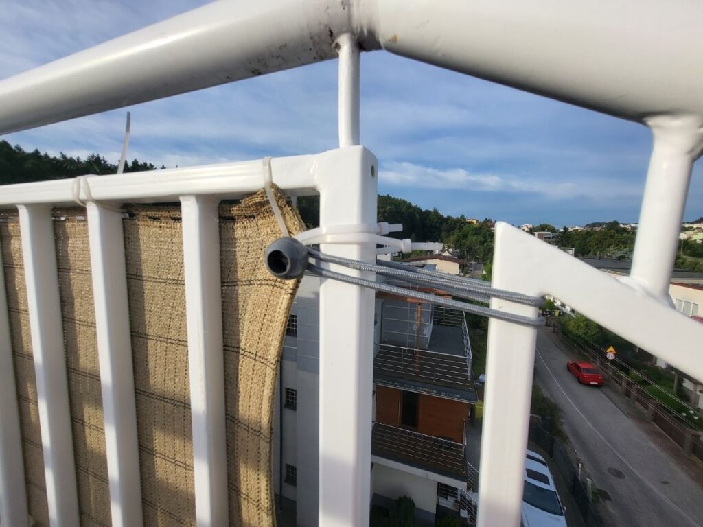 Close-up of wind screen securely attached to a rooftop railing